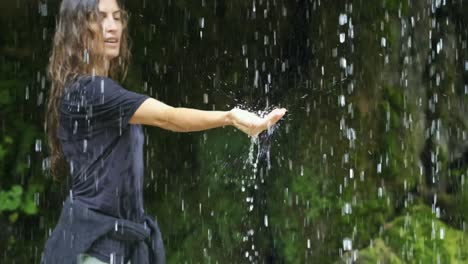 Frau-Tourist-Steht-Unter-Wasserfall