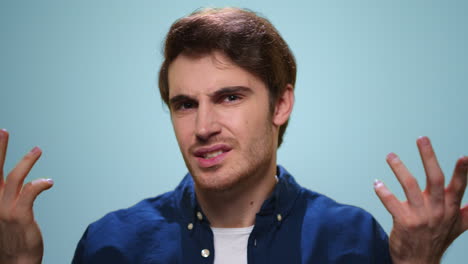 hombre disgustado gesticulando con las manos a la cámara. tipo molesto posando en el estudio