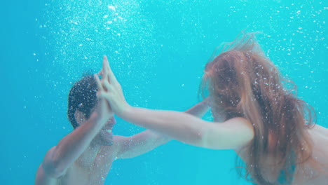 Happy-couple-swimming-underwater