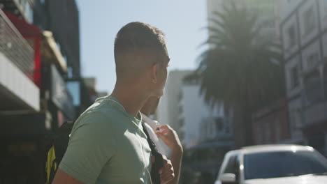 two mixed race male friends standing, trying to catch cab in the street