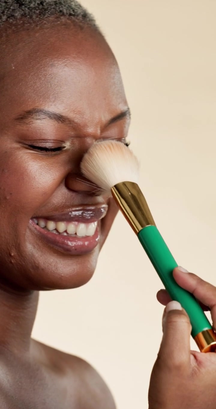 Happy Woman Applying Makeup with a Brush