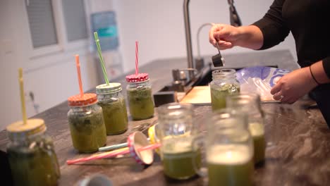 young latin girl prepare cocktail mocktail or smoothie at her kitchen