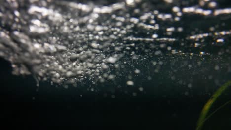 filmación submarina del flujo de agua. el agua fluye bajo presión. burboles y burbujas