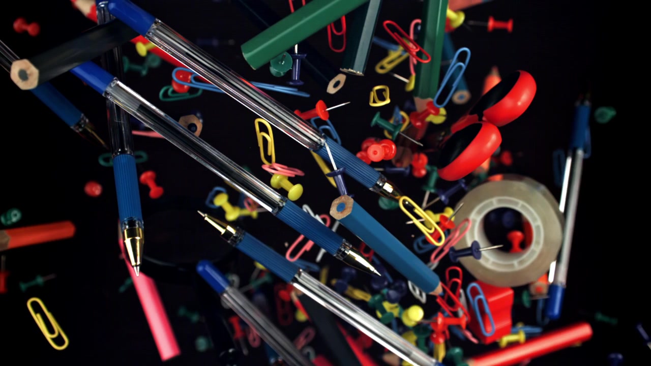Colorful Office and School Supplies Falling in Slow Motion on Black Background