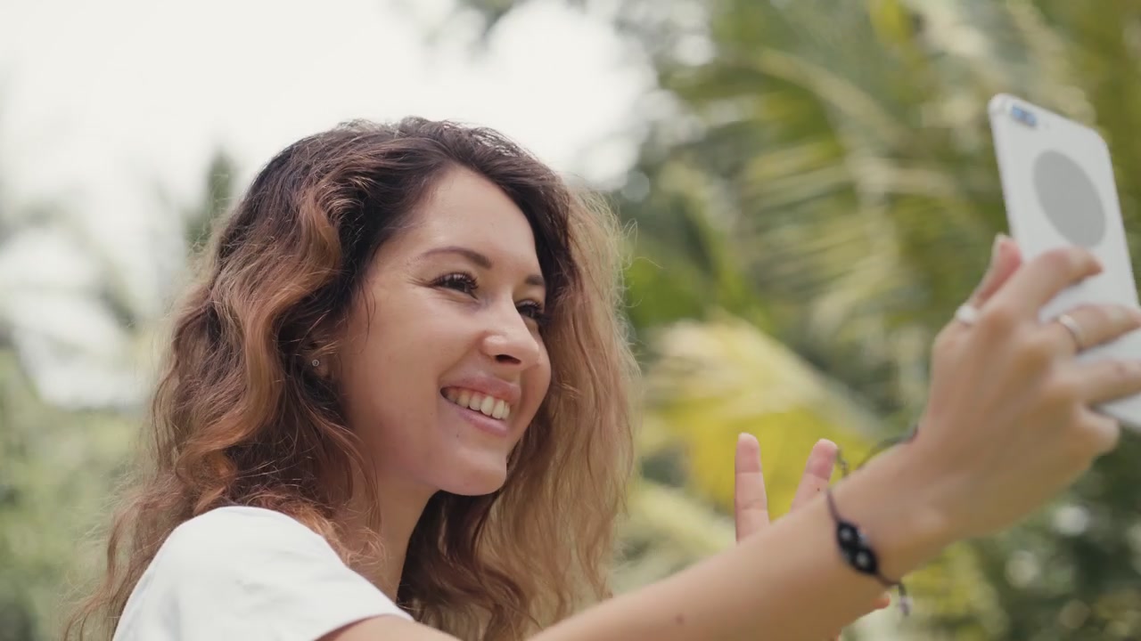 Giovane donna che si scatta un selfie con lo smartphone all'aperto