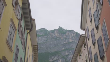 hermosa foto de los alpes italianos y dos edificios coloridos en el centro de riva del garda, un pequeño pueblo en la región de trento, norte de italia