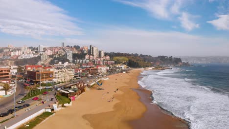 Aerial-dolly-back-above-renaca-Beach-at-Vina-del-Mar,-Chile,-with-pacific-ocean-at-side