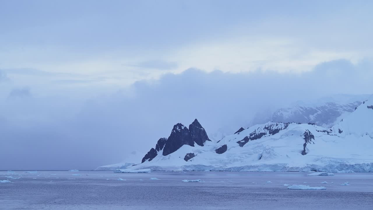 Sunset Winter Mountains and Ocean in Antarctica with Dramatic Clouds and Sky, Amazing Scenery on Antarctic Peninsula Coast, Sunset Coastal Scenery in Icy Snowy Scene in Cold Weather