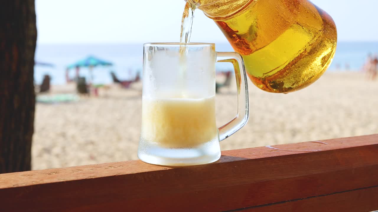 해변 에 있는 유리잔 에 맥주 가 여 있다