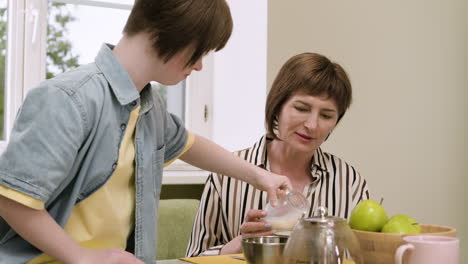 mutter unterhält sich mit ihrer tochter, während sie milch serviert