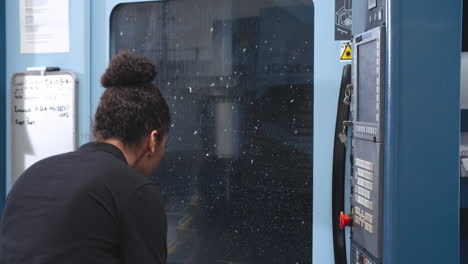 female engineer operating cnc machinery on factory floor