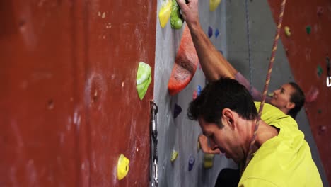 man and woman climbing the artificial wall 4k