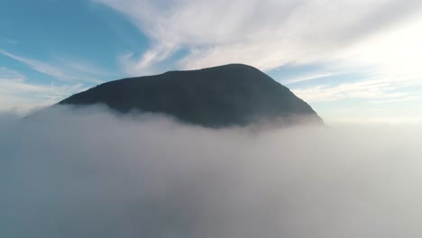 mountain piercing through clouds