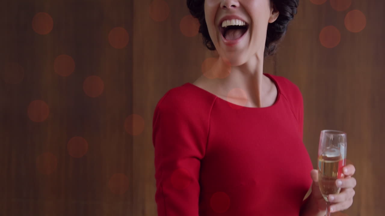 animación de puntos de luz sobre una mujer caucásica sonriente agitando con champán