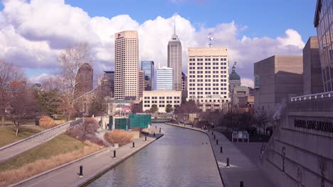 establishing shot of downtown city skyline and riverfront walk indianapolis indiana