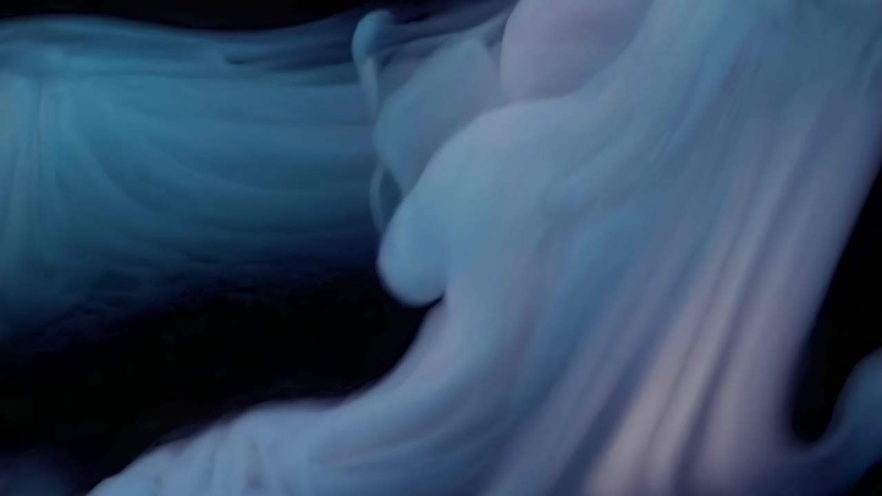 Abstract video of swirling blue smoke captured from a high-angle, creating a mysterious and ethereal