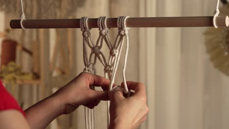 mujer haciendo macrame colgado en la pared