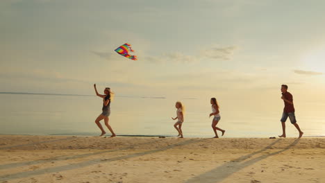 Group-Of-Niños-Playing-With-Adults-Let-Them-Into-The-Sky-Kite-Fun-Running-On-The-Beach