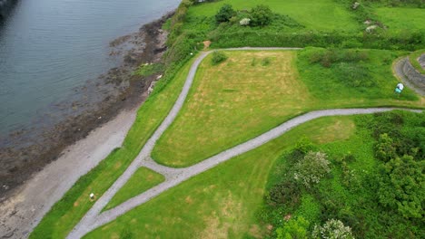 Small-park-with-pathways-and-vibrant-green-grass-by-the-shore-of-Valentia-River