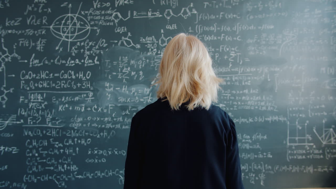 Woman looking at a chalkboard full of math equations