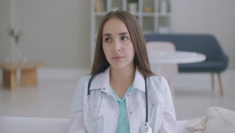 Looking-at-the-camera-listening-woman-doctor-looks-at-the-camera-and-listens-to-the-patient.-A-video-conference-listener.-Portrait-of-a-doctor