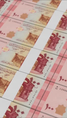 vertical video of 100 syrian pound banknotes printed by a money press