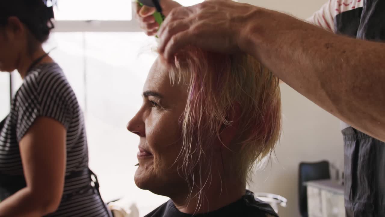 vista lateral mujer con el cabello seco por un peluquero
