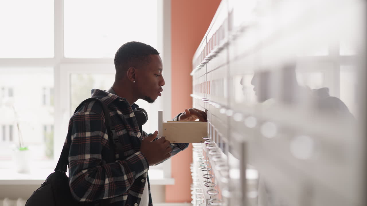 Man seeks for library ticket in drawer. Man searches for relevant information standing in front of card index boxes in archive. Paperwork concept