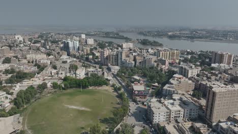 drone vuela sobre la ciudad de sukkur casas altas y el río indus en el fondo