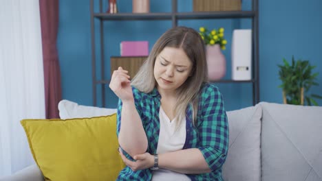 mujer joven con dolor de codo.