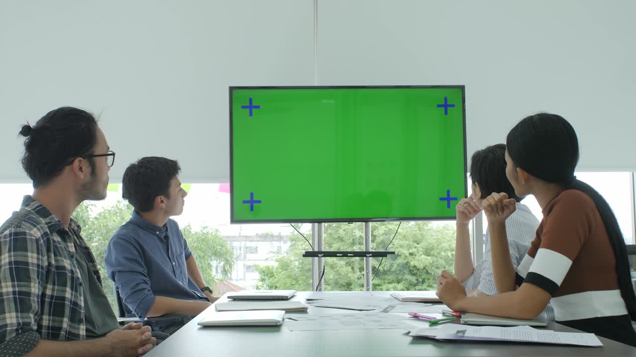 크리에이티브 비즈니스 팀은 회의실에서 녹색 스크린을보고 있습니다.