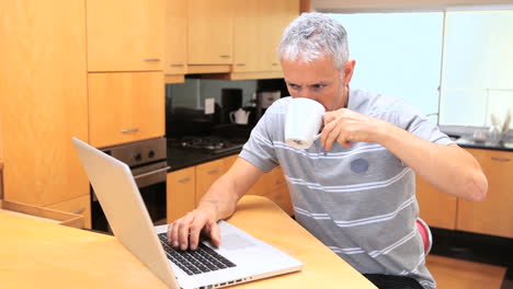 hombre sonriente usando una computadora portátil