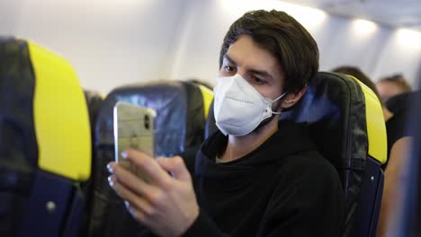 hombre con teléfono inteligente dentro del avión