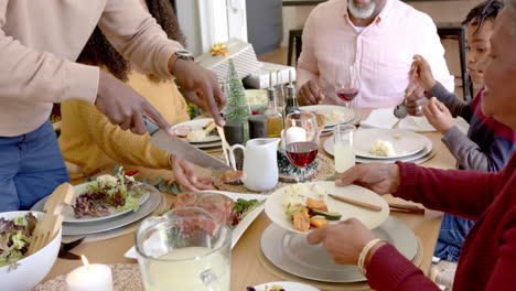 Padre-Afroamericano-Tallando-Carne-En-La-Mesa-De-La-Cena-Familiar-De-Varias-Generaciones.