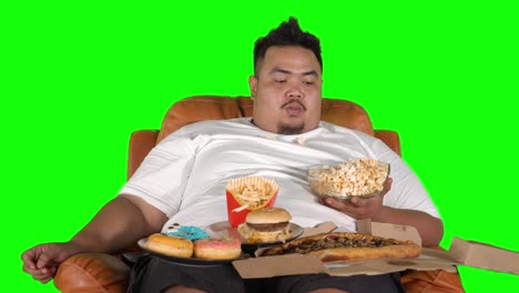 greedy obese man eating popcorn and fast foods