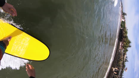 vertical video, pov gopro of person surfing on wave on foamboard, then falling