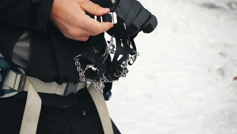 a hiker trying to put crampon on his winter boots