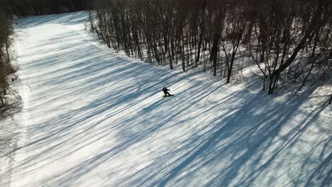 the aerial footage showcases a young snowboarder gracefully shredding down on the empty slopes of yabuli resort with remarkable speed and agility, creating a truly mesmerizing experience