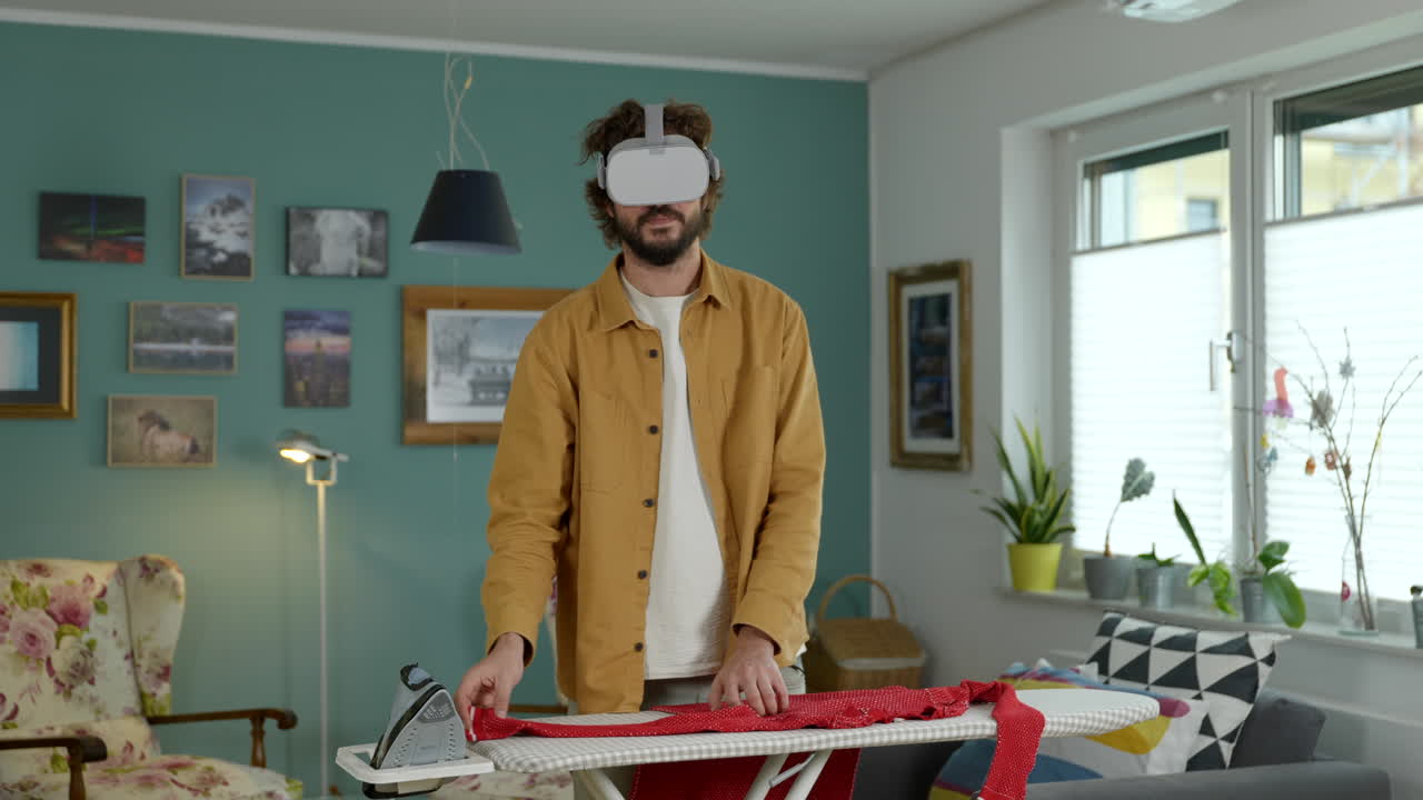 hombre adulto joven planchando ropa con tecnología de gafas de realidad virtual en un hogar moderno