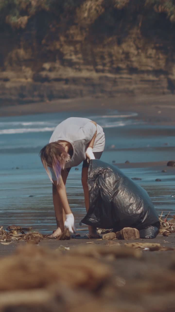 Volunteer cleans up plastic waste on bali beach to protect marine life