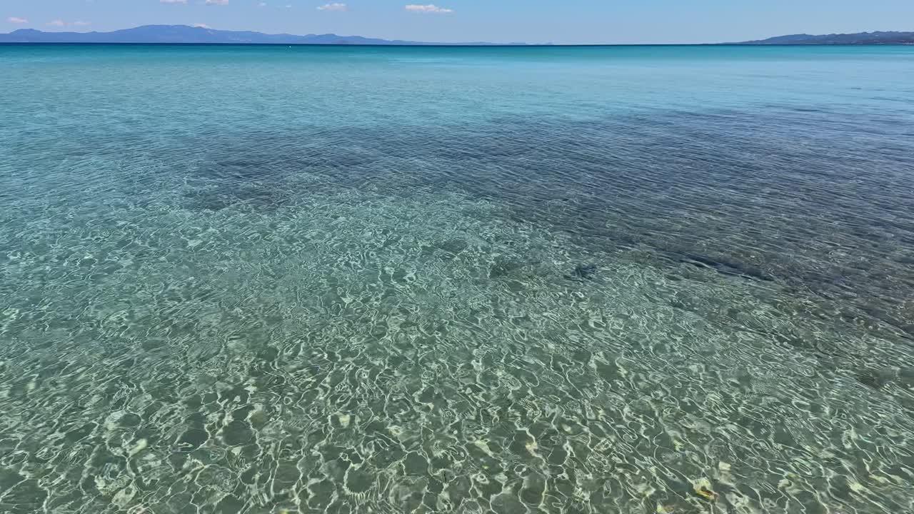 Stunning beach scene in Halkidiki, Greece, with elegant sunbeds facing the crystal-clear turquoise sea. A perfect summer escape in the heart of the Aegean.