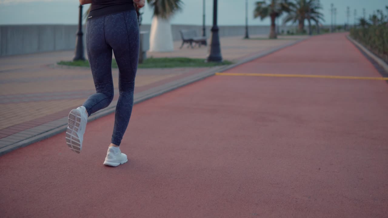 mujer corriendo por un camino costero