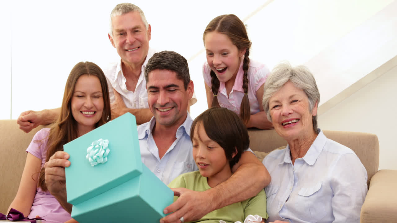 아버지가 선물을 열는 것을 지켜보는 대규모 가족