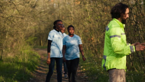 captain of the search party directs his team through the woods