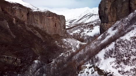 Flying-in-rugged-terrain-between-two-cliffs-with-hiking-trails-below