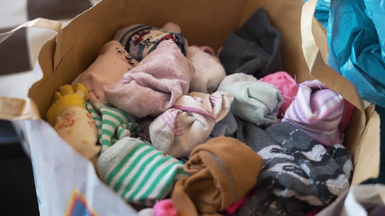 куча красочных носков в бумажном пакете в помещении