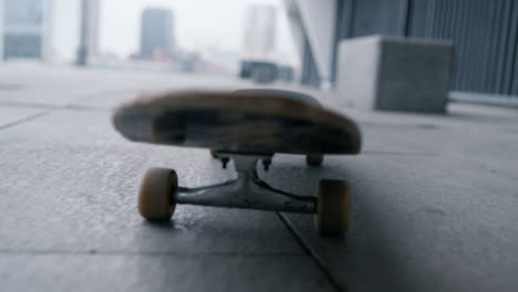 closeup skateboard wheels spinning outdoor. skate rolling along city street.