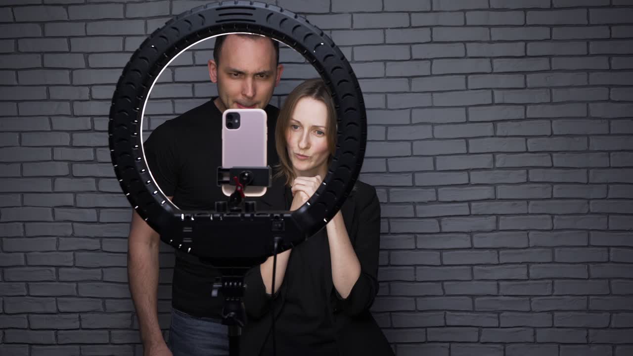 video de una pareja de bloggers contando una historia en el fondo de una pared de ladrillo