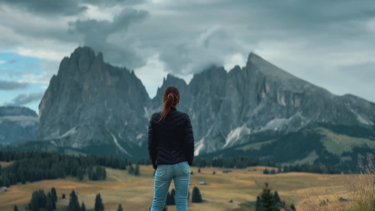 Slow motion video of a woman admiring the mountains and landscape of Alpe di Suisi in the Dolomites