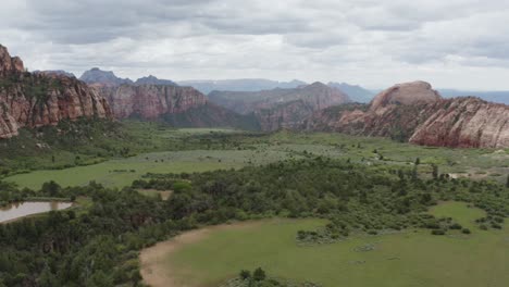 toma panorámica lenta y amplia del valle del parque nacional zion, hierba verde y rocas rojas prominentes